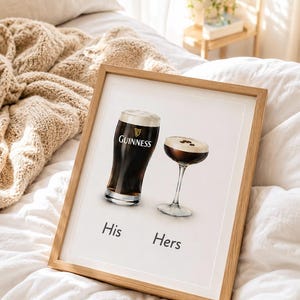 Puede incluir: Impresi&oacute;n enmarcada con dos bebidas: una pinta de Guinness y un c&oacute;ctel. La pinta de Guinness tiene el logotipo de la marca. Las palabras "His" y "Hers" est&aacute;n debajo. Marco de madera clara.