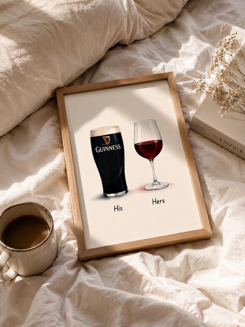 May include: A framed print featuring a pint of Guinness and a glass of red wine, labeled "His" and "Hers". The Guinness glass is black with a white head, and the wine glass is filled with red wine. The print is in a wooden frame.
