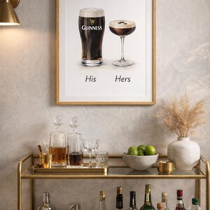 Puede incluir: Un cuadro enmarcado con una pinta de Guinness y un c&oacute;ctel, etiquetados como "His" y "Hers". La imagen est&aacute; sobre un carrito de bar dorado con varias botellas, copas y un cuenco con limas. Tambi&eacute;n hay un jarr&oacute;n decorativo con flores secas.