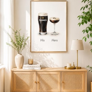 Puede incluir: Impresi&oacute;n enmarcada con dos bebidas: una pinta de Guinness y un c&oacute;ctel. Las palabras "His" y "Hers" est&aacute;n debajo. La impresi&oacute;n cuelga sobre un mueble de madera clara con puertas de ca&ntilde;a tejida, una l&aacute;mpara y objetos decorativos.