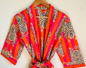 May include: A vibrant, open-front robe with a tiger print. The robe features a repeating pattern of tigers in black and tan against a background of vertical stripes in bright orange and pink. The robe has a matching tie belt.