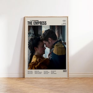 以下が含まれることがあります： 映画「The Empress」のフレーム入りポスター。時代衣装を着たカップルが描かれています。ポスターはベージュの背景に黒い文字でタイトルが書かれています。2022年が右下に表示されています。