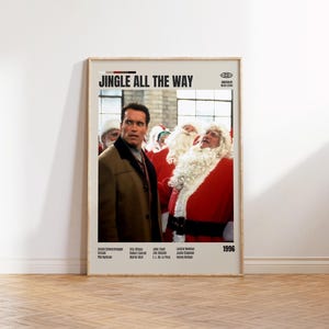 May include: A framed movie poster for "Jingle All the Way" featuring Arnold Schwarzenegger in a brown coat, with Santa Claus figures in the background. The poster has the movie title and the year 1996.