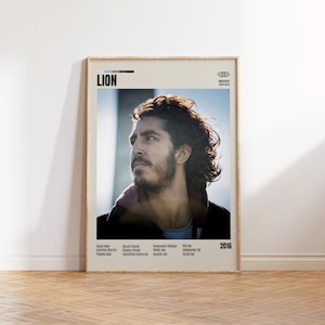 Op de afbeelding: Een ingelijste filmposter voor "Lion" met een portret van een man met donker haar en een baard. De poster bevat de filmtitel, cast- en crewcredits en het jaar 2016.