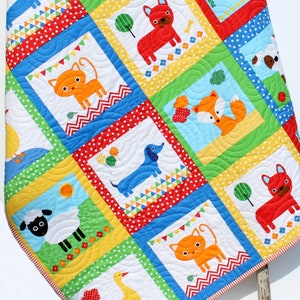 May include: A colorful baby quilt with a patchwork design featuring various animals, including a fox, cat, dog, panda, duck, and sheep. The quilt is made with bright colors and playful patterns.