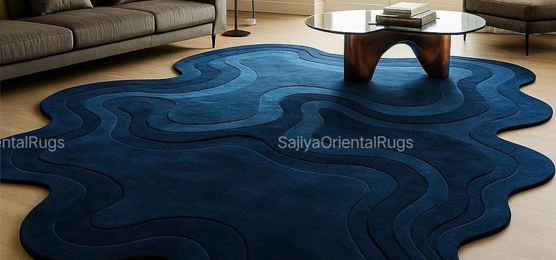 Custom-sized deep blue hand-tufted rug partially rolled to show backing and craftsmanship, with visible wool pile and sturdy construction