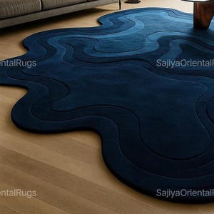 Deep blue abstract rug with irregular edges placed in a modern kids room with a white crib, wooden toys, and colorful wall art