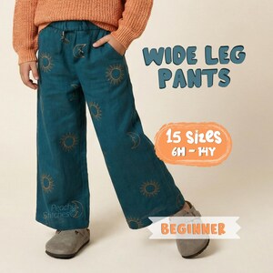 May include: Teal wide-leg trousers with a drawstring waist, adorned with a repeating sun and moon pattern. Part of the "Beginner" collection, available in 15 sizes, from 6 months to 14 years. The trousers are worn with a rust-coloured jumper.