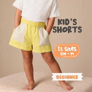 May include: Yellow kid's shorts with cream pockets. The shorts are part of a beginner sewing pattern with 13 sizes available, ranging from 12 months to 14 years. The text "Kid's Shorts" is displayed in a dark grey font.