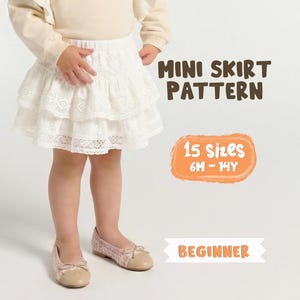 Può includere: Una minigonna bianca a balze in pizzo con elastico in vita. Il testo sull'immagine recita MINI SKIRT PATTERN, 15 sizes 6M - 14Y, e BEGINNER. La gonna presenta un design a strati con dettagli in pizzo intricati su tutto il tessuto.