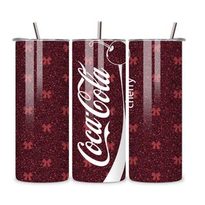 May include: A set of three stainless steel tumblers with lids and straws. The tumblers have a dark red glitter finish with small red bow accents. The center tumbler features the Coca-Cola logo and the word "cherry".