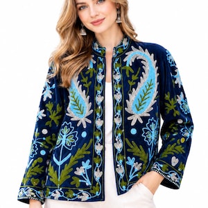 May include: A navy blue velvet jacket featuring an open front and a mandarin collar. The garment is decorated with intricate embroidery in shades of light blue, silver, and olive green, showcasing floral and large paisley motifs throughout.