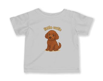 May include: White t-shirt featuring a cartoon illustration of a brown puppy with the text "little cutie" above it in yellow. The puppy is sitting and has a friendly expression. The shirt is made of a soft material.