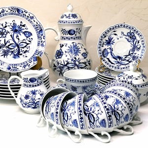 Könnte beinhalten: Ein Teeservice aus Porzellan mit weißem Untergrund und blauen Blumenmustern. Das Set besteht aus einer Teekanne mit Deckel, einem Milchkännchen, einer Zuckerdose mit Deckel, mehreren Tassen mit passenden Untertassen und Tellern mit botanischen Motiven.