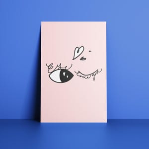 May include: A pink poster with a black and white eye illustration. The eye is winking, with eyelashes and hearts drawn above. The word "eye" is written above the eye. The poster is leaning against a blue wall.