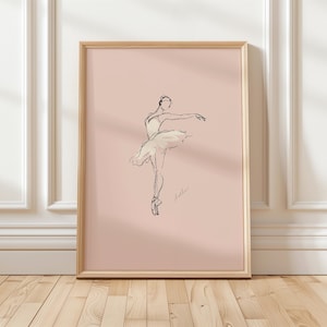 Pode incluir: Impressão de arte emoldurada com um esboço minimalista de uma bailarina em uma pose graciosa. A obra de arte é renderizada em linhas pretas sobre um fundo rosa suave, com uma moldura de madeira. A bailarina está usando um tutu e sapatilhas de ponta.