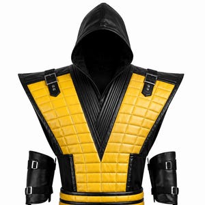 May include: A black and yellow hooded vest featuring a quilted pattern, a high collar, and two shoulder straps with silver buckles. The garment includes a wide, multi-layered waist belt and two separate black forearm guards with silver buckles.