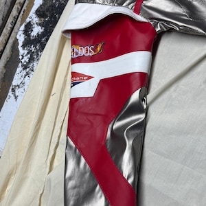 May include: Silver and red racing jacket with white accents. The jacket features a quilted design and a black collar. The sleeve has the text "DOS" and "ctane".