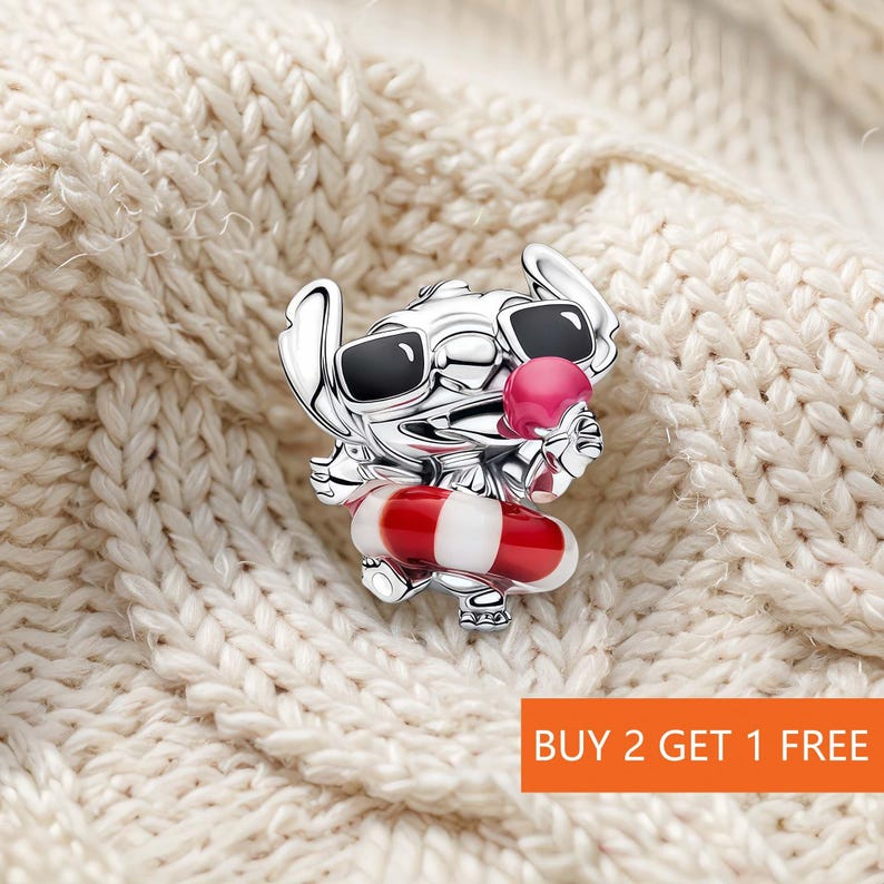 May include: A silver-toned charm featuring a character wearing black sunglasses and holding a pink ice cream cone. The character is positioned inside a red and white striped life preserver ring. The charm has a polished metallic finish.