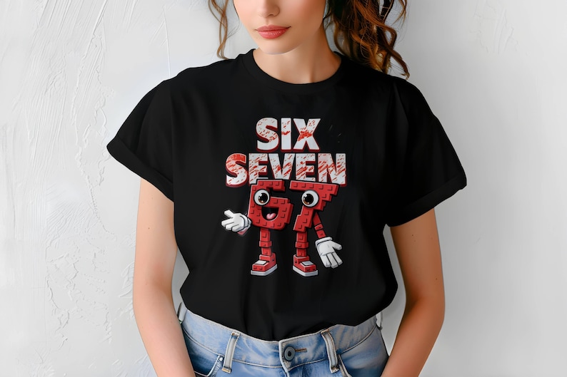 May include: Black t-shirt featuring the words "SIX SEVEN" in a distressed, brick-like font. Below the text is a cartoon character made of red bricks, resembling the numbers 67, with white gloves and shoes.