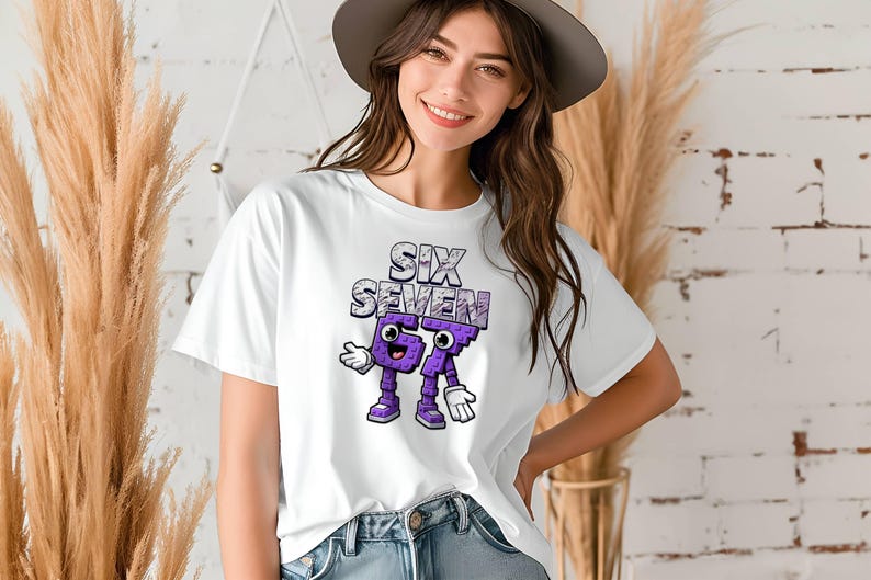 May include: White t-shirt featuring the text "SIX SEVEN" in a textured design above cartoon-like numbers. The numbers are purple with white gloves and shoes. The shirt is worn by a person.