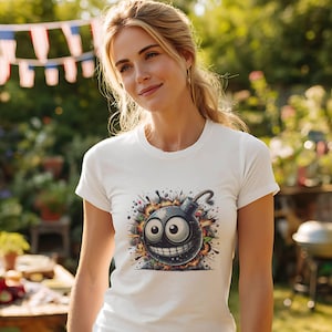 May include: White t-shirt featuring a cartoon bomb design with a smiling face, large eyes, and a lit fuse. The graphic includes colorful explosion effects. The shirt is short-sleeved and has a crew neck.