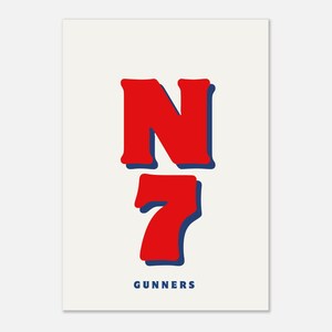 May include: A print on a cream background features the red letter "N" above the red number "7", both with blue shadow outlines. The word "GUNNERS" is printed in blue at the bottom of the image.