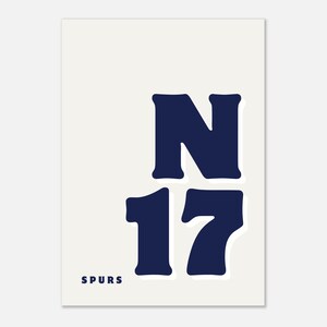 May include: A minimalist art print on a cream background. The design features the letter "N" and the number "17" in navy blue, with the word "SPURS" at the bottom. The typography is bold and rounded.
