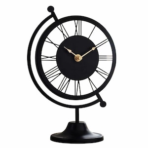 Black metal desk clock in a globe design. The clock features a black face with gold hands and Roman numerals. The clock is supported by a black base and a circular frame. A decorative accent for a home or office.