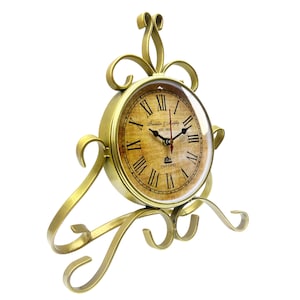 May include: A gold-colored, vintage-style clock with Roman numerals on the face. The clock features the text "Franklin & Murphy" and "Oxford". The clock is supported by an ornate, scrolled base and top.