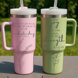 May include: Two insulated tumblers with handles, one pink and one green, each with a lid and straw. The pink tumbler has the text "Trust in the Lord..." and the green tumbler has the text "The joy of the Lord...". Both have floral designs.
