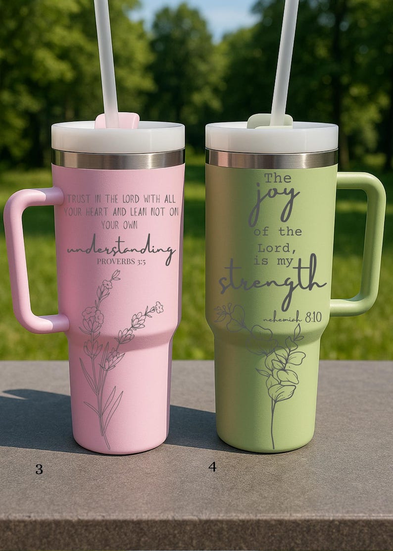 May include: Two insulated tumblers with handles, one pink and one green, each with a lid and straw. The pink tumbler has the text "Trust in the Lord..." and the green tumbler has the text "The joy of the Lord...". Both have floral designs.