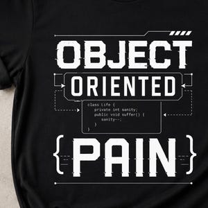 May include: A black short-sleeved t-shirt featuring white graphic text that reads OBJECT ORIENTED PAIN. The design includes a small code snippet block that says class life { private int sanity; public void suffer() { sanity--; } }.