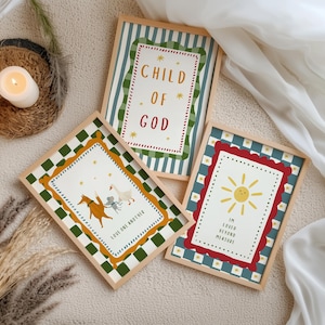 May include: Three framed art prints with wooden frames. One print reads "CHILD OF GOD" in red and gold. Another features a horse, goose, and angel with the text "LOVE ONE ANOTHER". The third print shows a sun and the text "I'M LOVED BEYOND MEASURE".