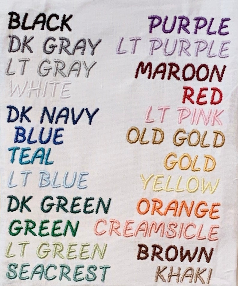 May include: A white fabric swatch with a list of colors and their names embroidered in different colored threads. The colors include black, dark gray, light gray, white, dark navy, blue, teal, light blue, dark green, green, light green, seacrest, purple, light purple, maroon, red, light pink, old gold, gold, yellow, orange, creamsicle, brown, and khaki.