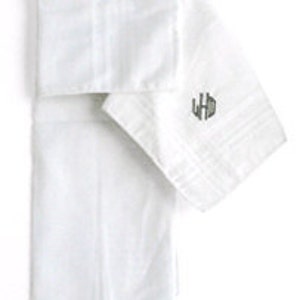 May include: Two white linen handkerchiefs with a monogrammed initial "LHD" embroidered in gray on one handkerchief.