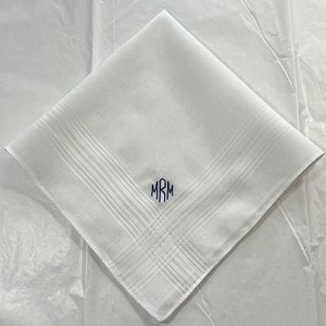 May include: White linen handkerchief with a monogram of the initials "MRM" embroidered in navy blue.