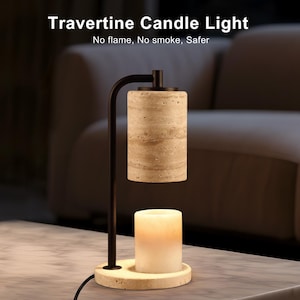 Op de afbeelding: Een Travertine Candle Light kaarsverwarmer met een zwarte metalen standaard, een cilindrische beige travertijn stenen kap en een ronde travertijn voet. De tekst Travertine Candle Light en No flame, No smoke, Safer is boven de lamp zichtbaar.