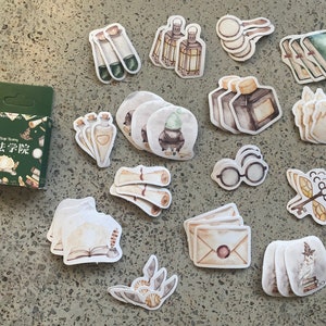 Pegatinas mágicas: caja de 45 artículos escolares de magia, varitas, pociones, llaves voladoras, cartas, pergamino para diario, agenda