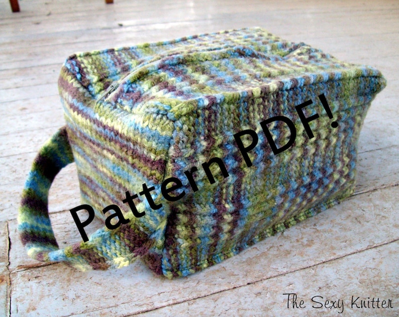 May include: A green, blue, and brown knitted tote bag with a zipper closure and a handle. The bag has the text "Pattern PDF!" printed on it.
