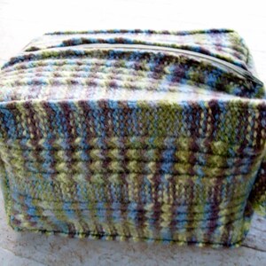 May include: A knitted zippered pouch with a green, blue, and brown pattern.