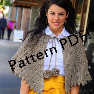 May include: A woman wearing a brown knitted shawl with a white shirt and a yellow skirt. The shawl has a lace pattern and pom poms. The text "Pattern PDF!" is superimposed on the image.