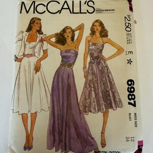 Könnte beinhalten: Ein McCall's Schnittmusterumschlag, Nummer 6987, mit Illustrationen von drei verschiedenen Kleidungsstilen. Der Umschlag zeigt den Markennamen, die Schnittmusternummer und Größeninformationen für eine Größe 12, Oberweite 34.