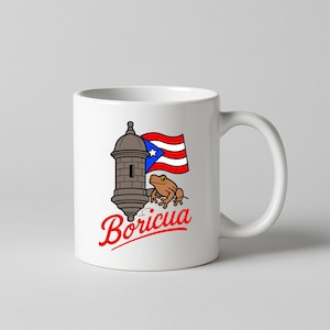 May include: White ceramic mug featuring a design with a brown fort, a Puerto Rican flag, and a brown frog. The word "Boricua" is written in red script below the design. The mug has a curved handle.