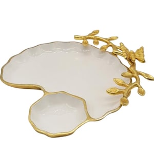 May include: A white serving tray with a gold-colored rim and a separate small dish. The tray has a decorative gold-colored butterfly and branch design on the side. The tray is designed for serving appetizers or small dishes.