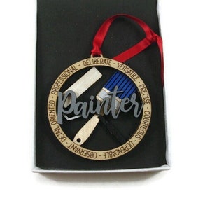 May include: Wooden ornament with a paintbrush and roller, and the word "Painter" in a decorative font. The ornament is surrounded by a circle of text that reads "Dependable - Courteous - Precise - Versatile - Deliberate - Professional - Detail Oriented".