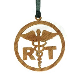 May include: A wooden ornament with a round shape and a brown color. The ornament features a medical symbol with a snake and wings, and the letters "RT" are cut out below the symbol.