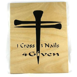 May include: A wooden sign with a black silhouette of a cross and three nails. The text "1 Cross 3 Nails 4 Given" is written below the cross.