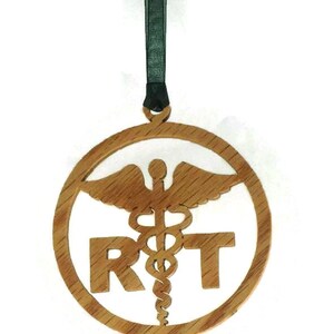 May include: A wooden ornament with a medical symbol and the letters "RT" in a circle. The ornament is hanging from a black ribbon.