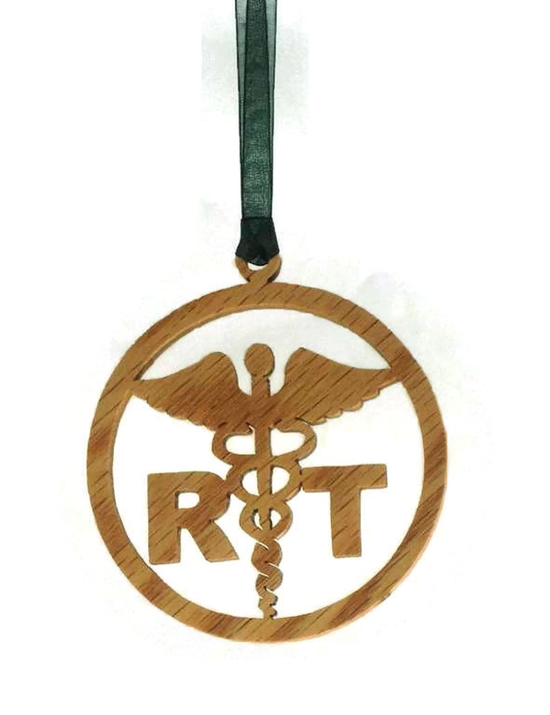 May include: A wooden ornament with a medical symbol and the letters "RT" in a circle. The ornament is hanging from a black ribbon.